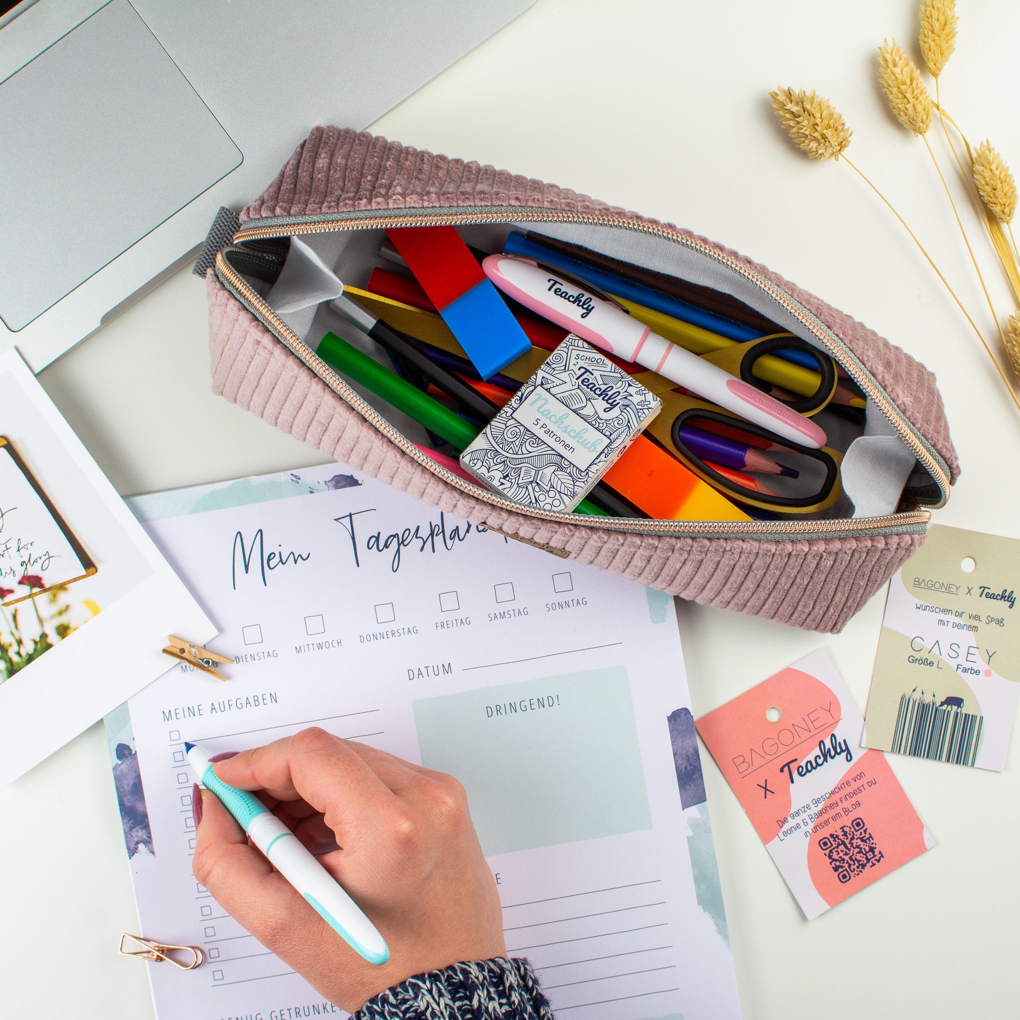 Das in Kooperation von Bagoney und Teachly entstandene CASEY L Cordstoff Mäppchen bzw. Federtasche gefüllt mit Stiften, Patronen, Radiergummis und Schere neben Schreibwaren
