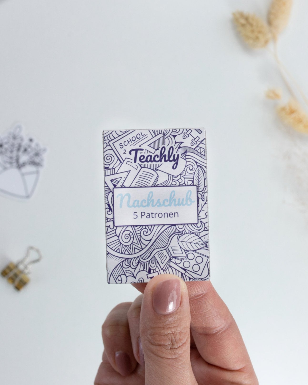 Nachschub Pack mit 5 Tintenrollerpatronen mit Schreibfarbe Blau für die beiden Teachly Tintenroller Superstudent & Superteacher in einer Hand gehalten