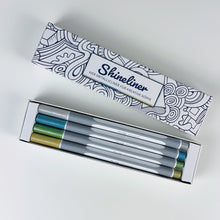 Lade das Bild in den Galerie-Viewer, Geöffnete Teachly Shineliner Classic Verpackung mit den vier Metallic Stiften in den Farben Silber, Blau, Grün und Gold
